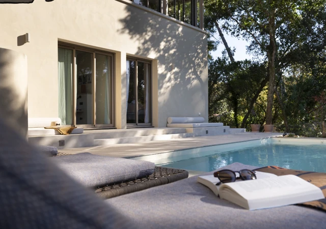 Espace détente avec bains de soleil au bord de la piscine de la Villa Madeleine